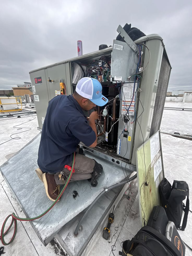 Technician servicing a large rooftop HVAC system
