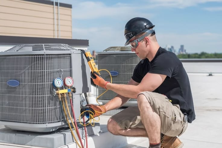 Technician checking refrigerant readings on rooftop HVAC equipment